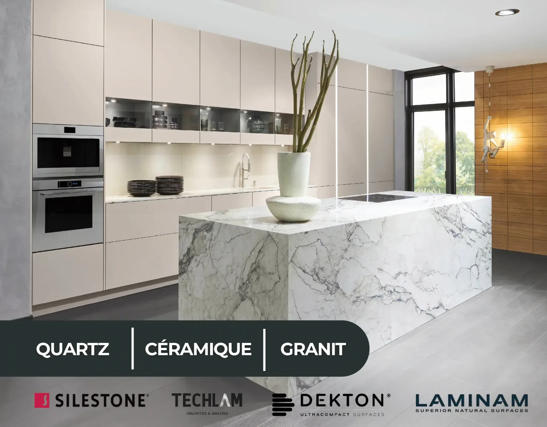 Cuisine aux façades beige clair, avec un grand îlot habillé d’un décor blanc veiné de gris jusqu’au sol